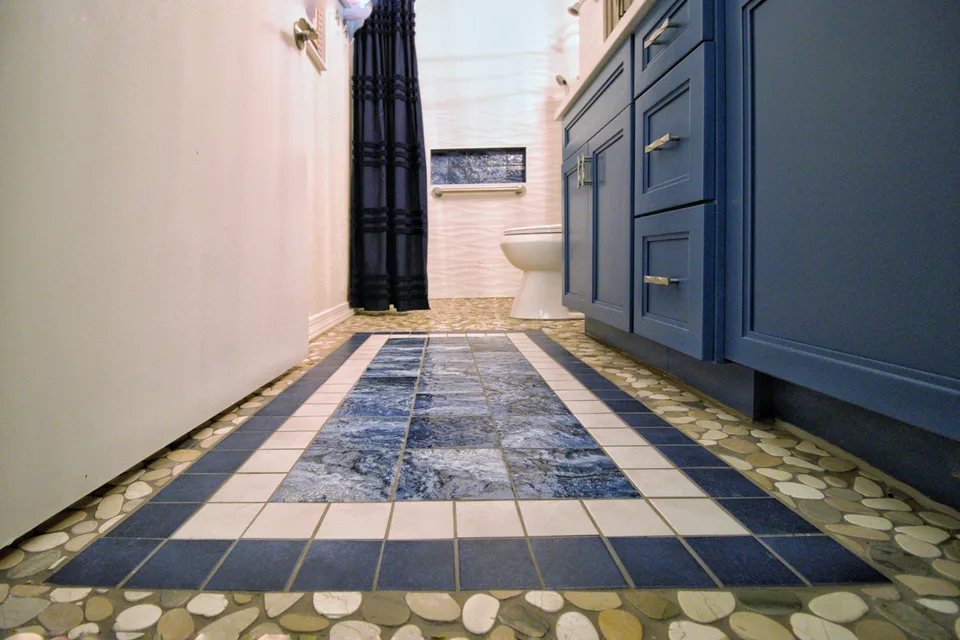 Slate and stone tile inset framed by river pebble mosaic