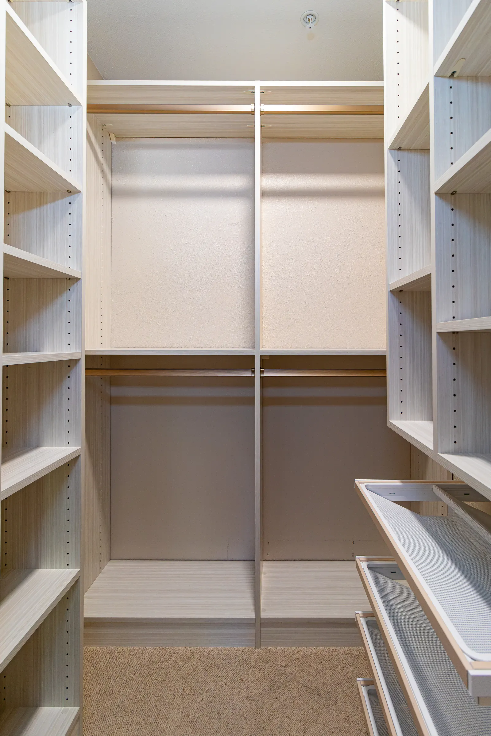 Custom walk-in closet with double-hang rods, corner shelving and adjustable shelf pinning