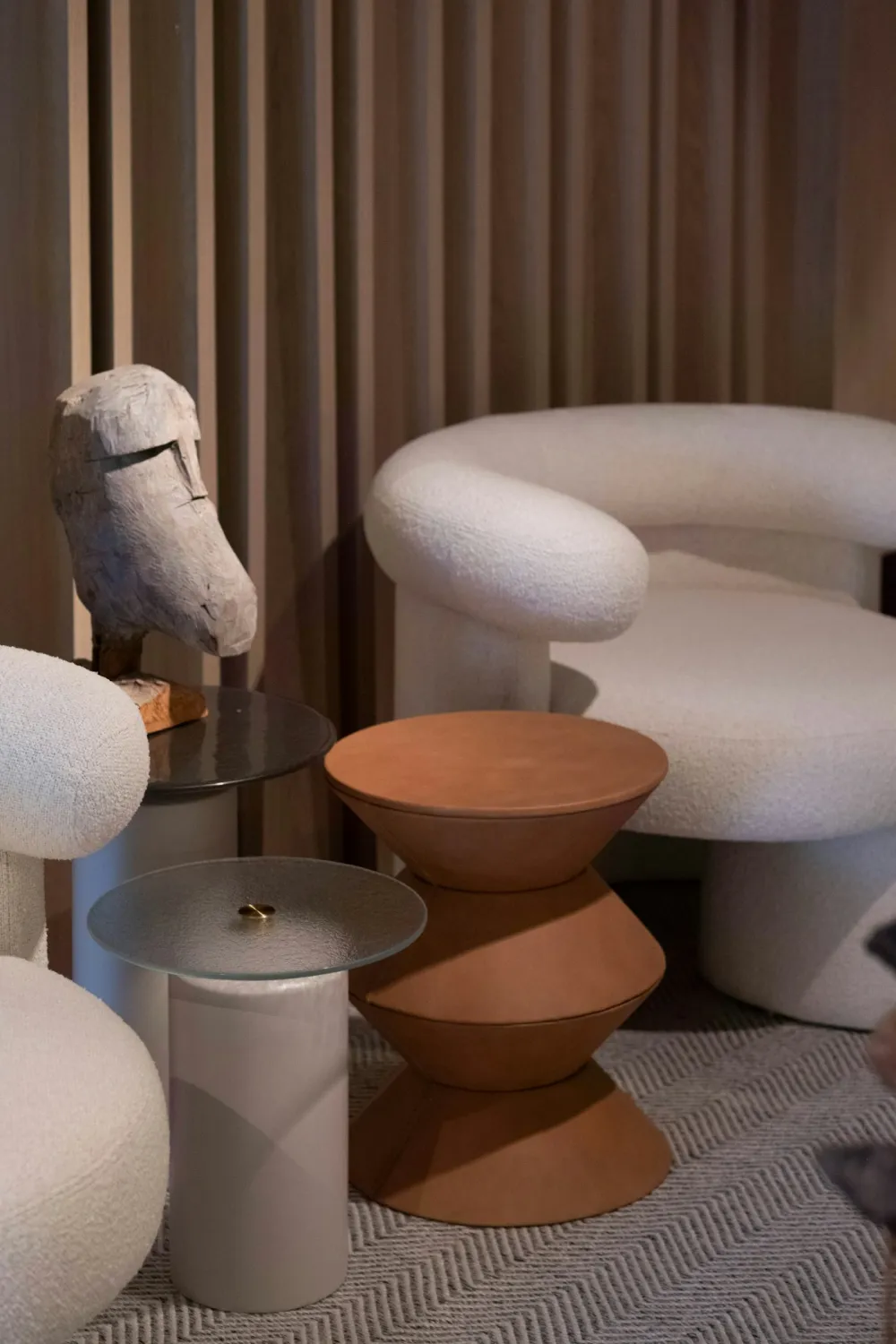 Sculptural travertine side tables on a wool rug